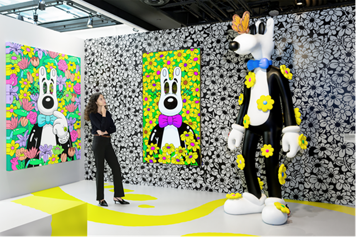 A photo of a woman looking at a sculpture of the character featured in the artwork