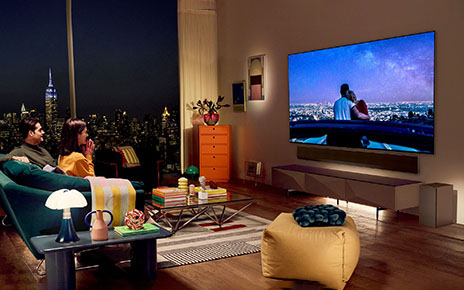 A photo of a couple in their living room watching television