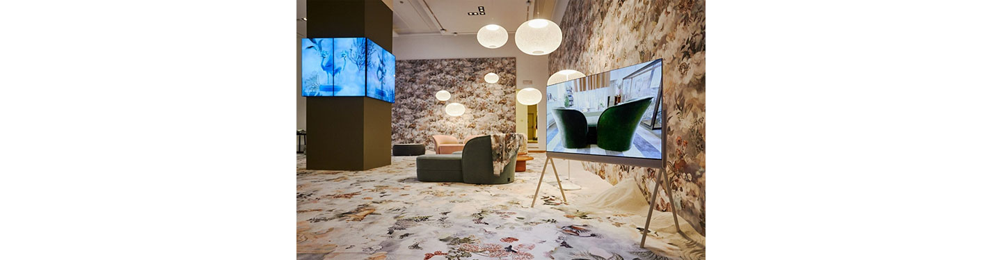 LG OLED Object Collection Posé on display at an exhibition with bright round lights and a variety of lifestyle furniture