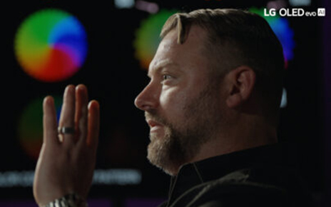 A picture of a man talking with his hand infront of his face
