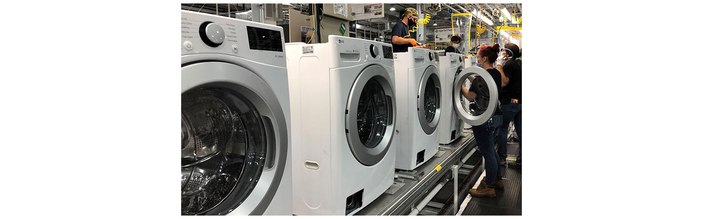 A team of US factory workers assembling LG washing machines moving down the production line