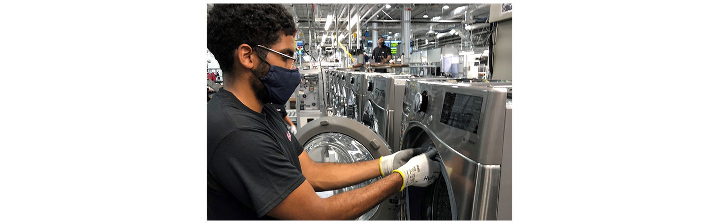 A closer look at one US factory worker fitting a part to the LG washer’s door