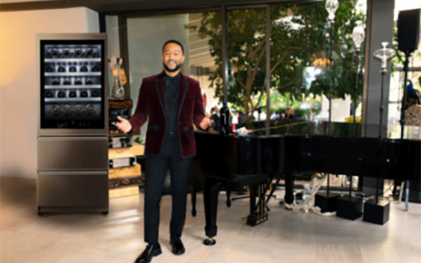 John Legend in suit posing in front of LG Wine Cellar