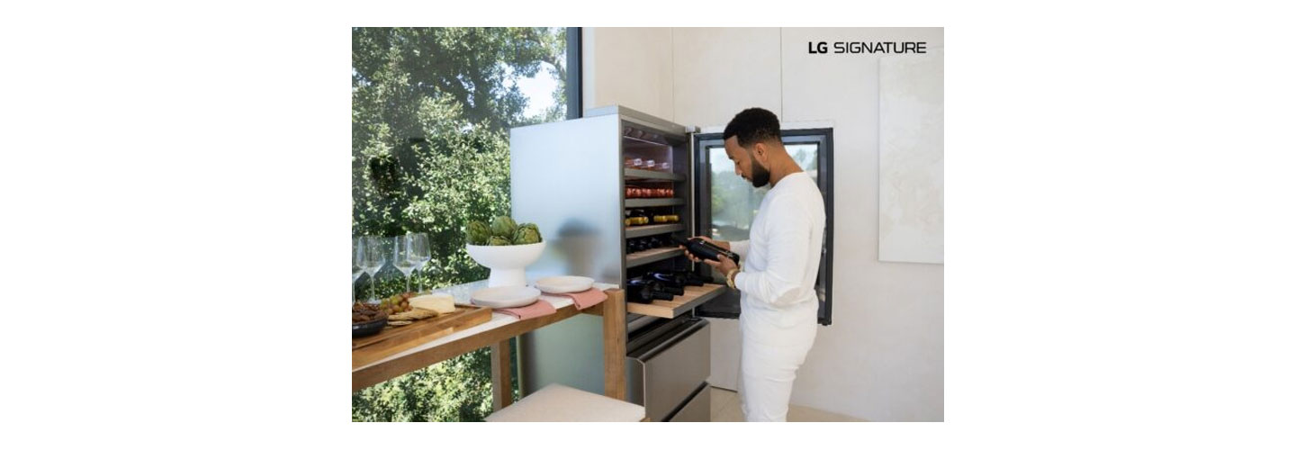 John Legend examining a bottle of wine after taking it from his LG SIGNATURE Wine Cellar