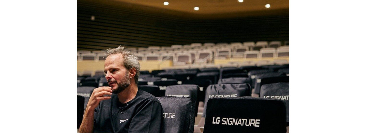 Yoann Bourgeois, the performance artist and choreographer, sitting in an empty LG SIGNATURE Hall at LG Arts Center SEOUL, as he looks onto the stage