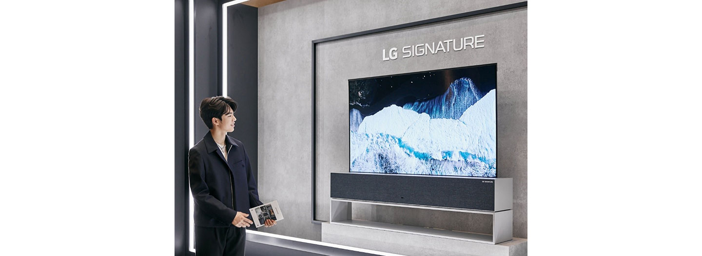 Professional ice skater Cha Jun-hwan admiring the LG SIGNATURE OLED R TV on display in the LG SIGNATURE Hall lobby