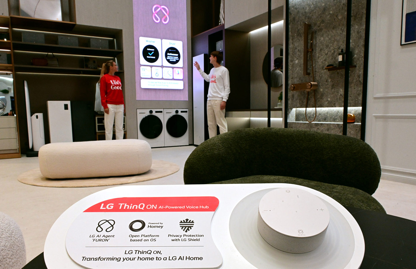 A picture of LG ThinQ display and two people in the background