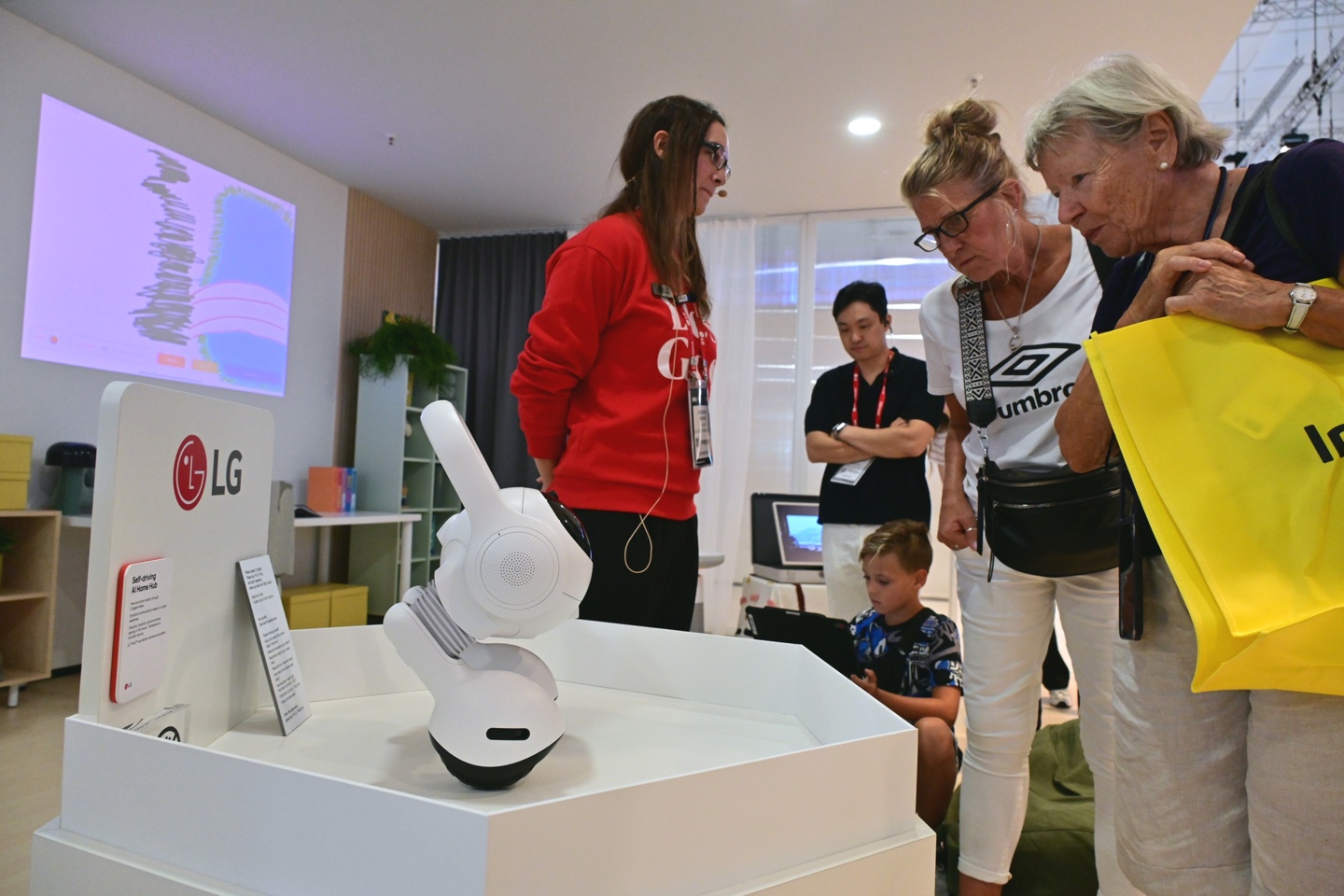 A picture of visitors looking closely at LG's AI products