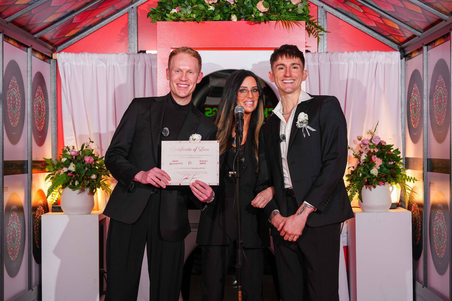 A photo of a couple and an officiate with a wedding certificate