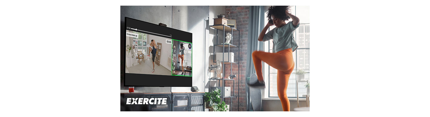 A woman exercising in her living room with LG OLED TV’s new fitness service, Xponential