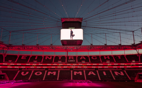 A stadium displays 'EINTRACHT VOM MAIN' on the seats with a "Depot" advertisement on the ceiling screen.