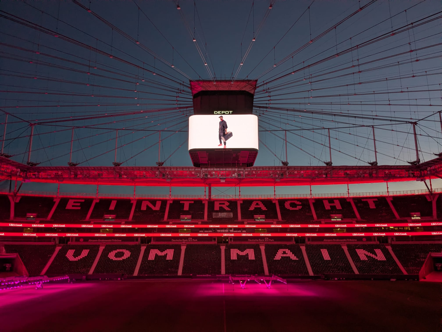 A stadium displays 'EINTRACHT VOM MAIN' on the seats with a "Depot" advertisement on the ceiling screen.