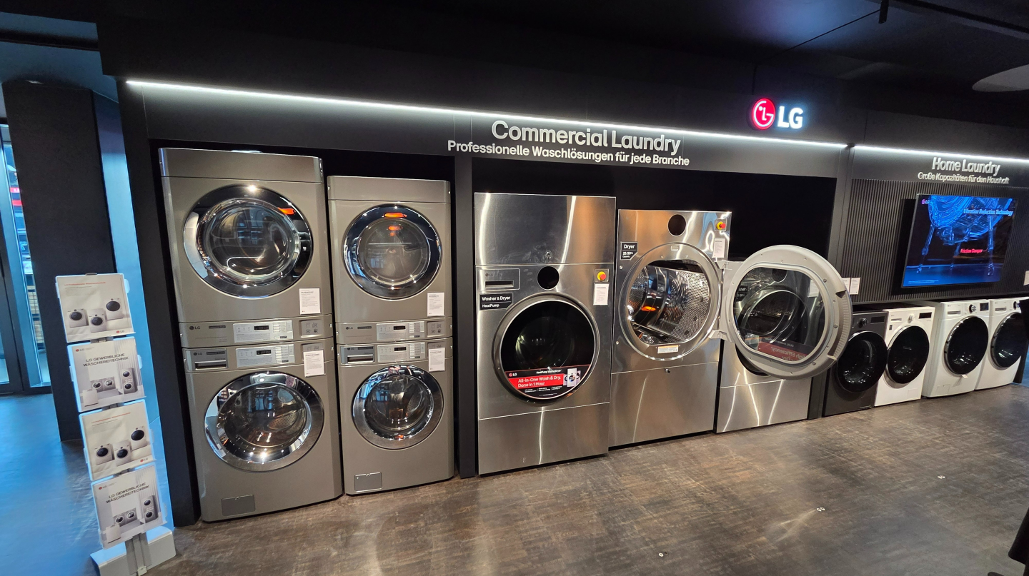 A variety of LG washers and dryers are on display in the "Commercial Laundry" area of the booth.
