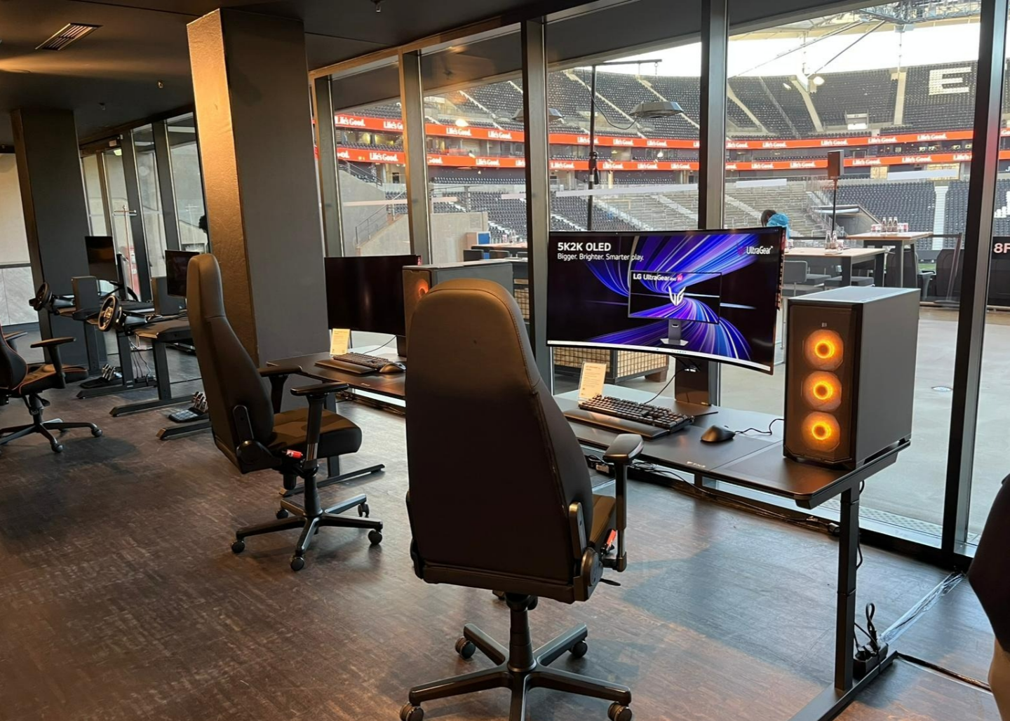 The nearest screen in a row of gaming setups features an LG UltraGear evo 52-inch G9 gaming monitor.