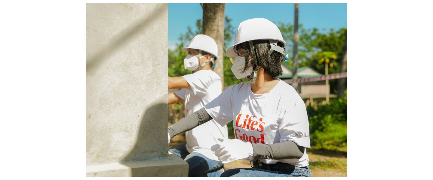 LG Vietnam employees painting a wall to renovate an old house