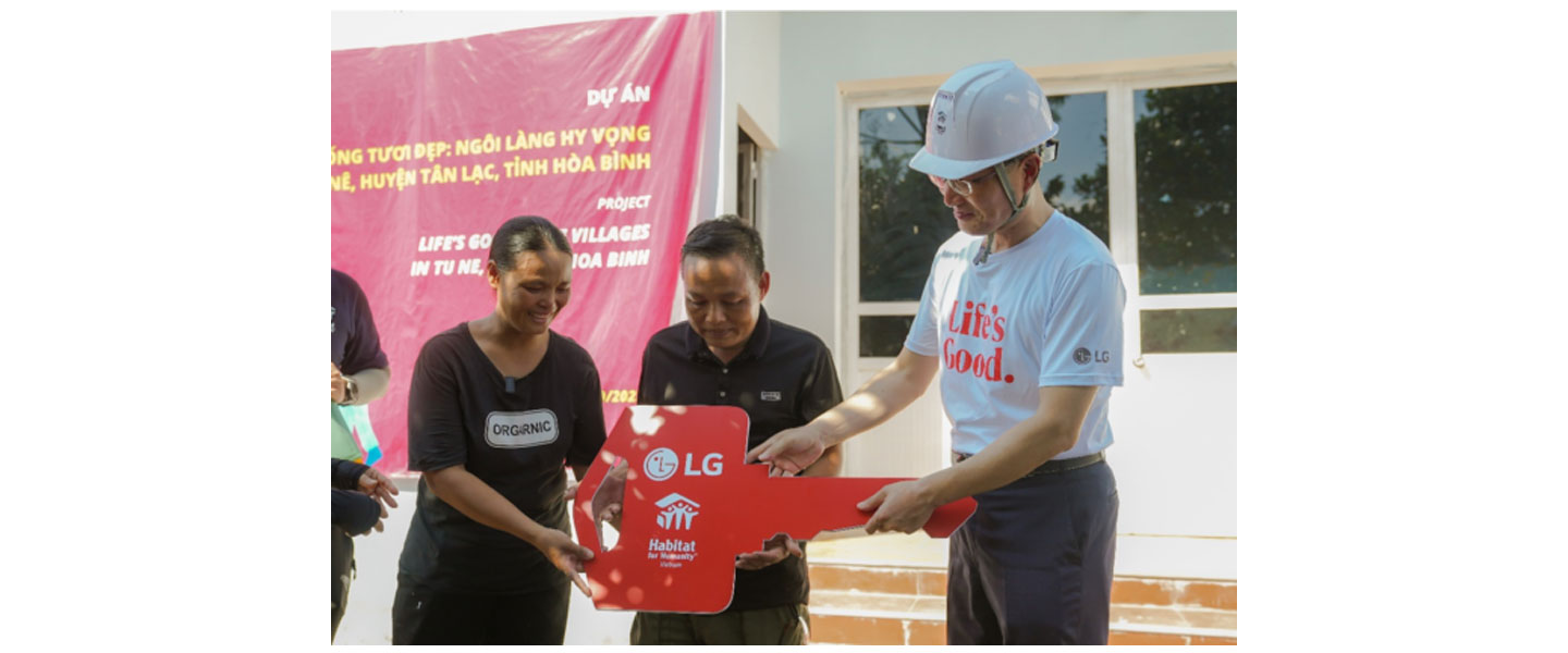 Song Ik-hwan, managing director of LG Electronics Vietnam, handing over a house key to a Muong family