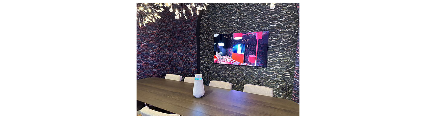 The 2023 LG Lifestyle screen mounted on the wall of a CES 2023 showroom with LG XBOOM speaker on the table in front