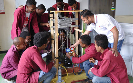 Young and eager Ethiopian trainees learning how to repair appliances under the teacher's guidance