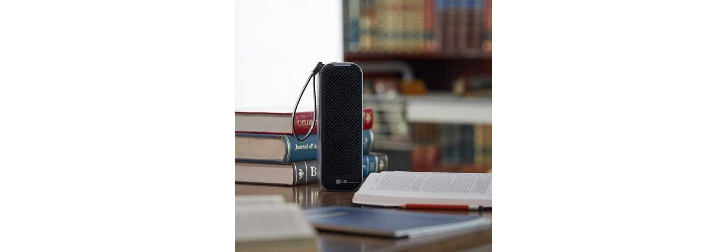 The front view of LG PuriCare Mini Air Purifier surrounded by books.