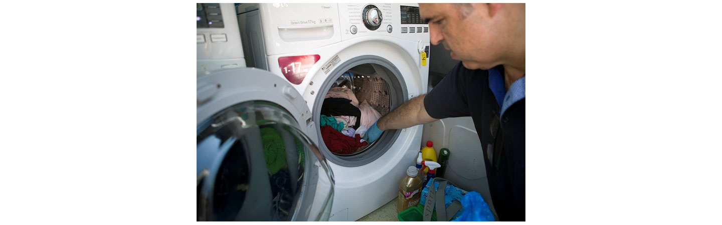 A man from Ithaca using an LG washing machine donated by LG Greece.