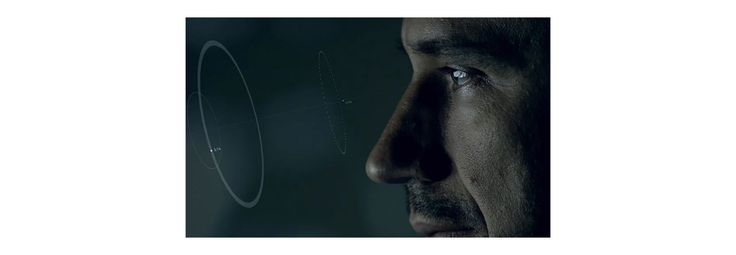 A closeup photo of a male looking closely at a hologram in a shape of a circle