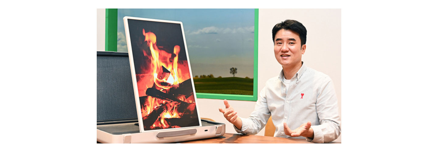 A campfire is displayed on the LG StanbyME Go model in portrait mode
