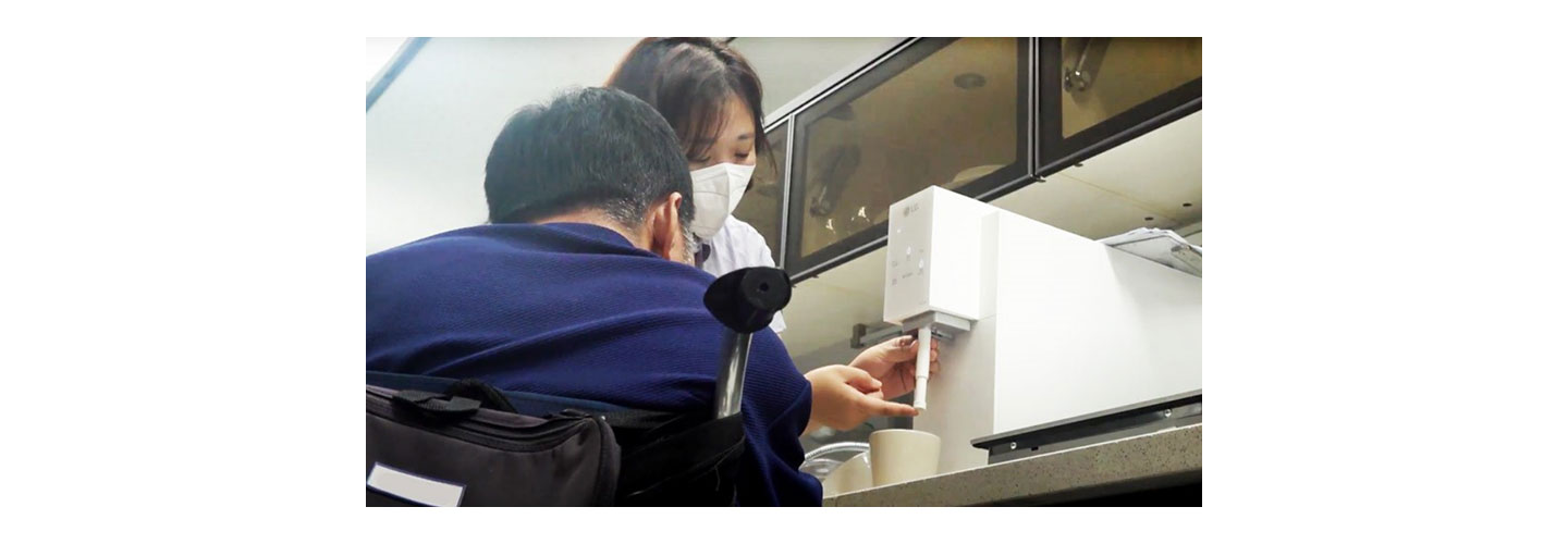 A man and a woman are testing the Easy Nozzle Kit applied to the LG water purifier