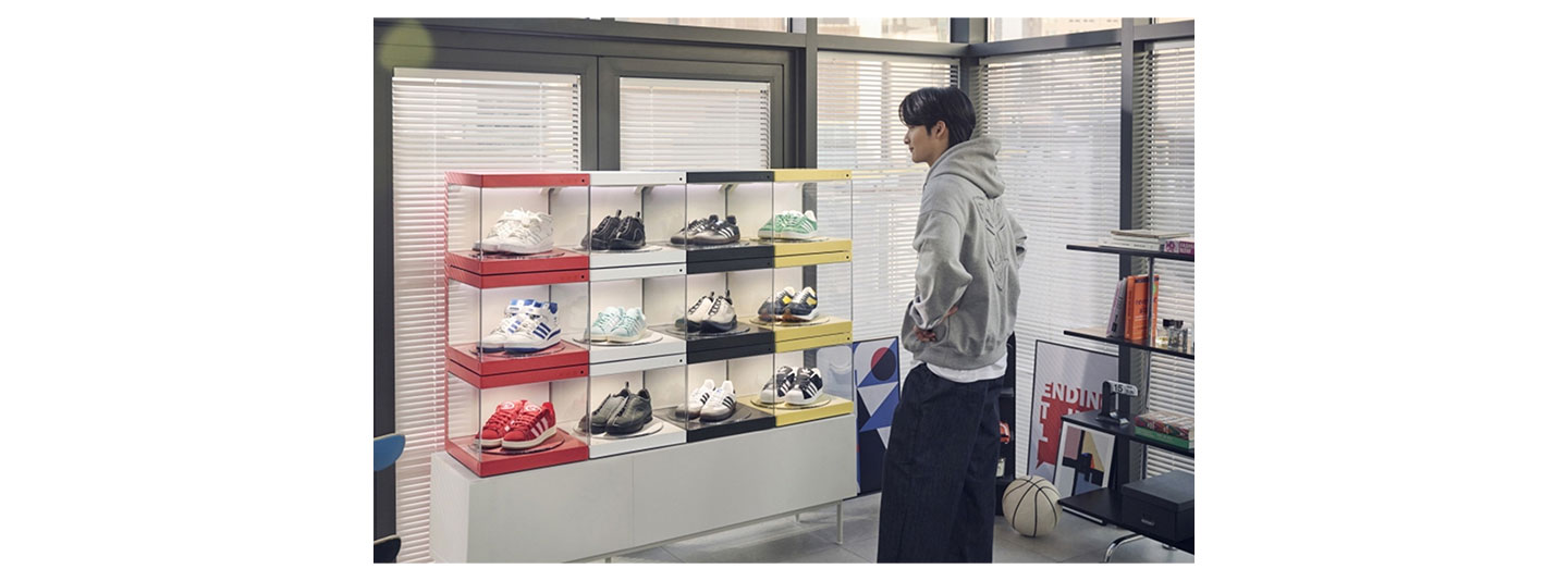 A man looking at a series of shoes neatly organized in LG Styler ShoeCase and ShoeCare