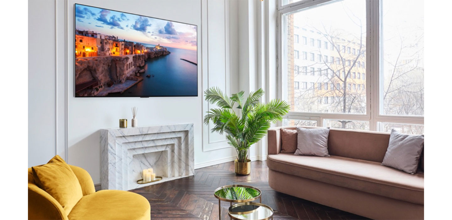 A 2023 LG OLED TV mounted on the wall of a bright, modern living room
