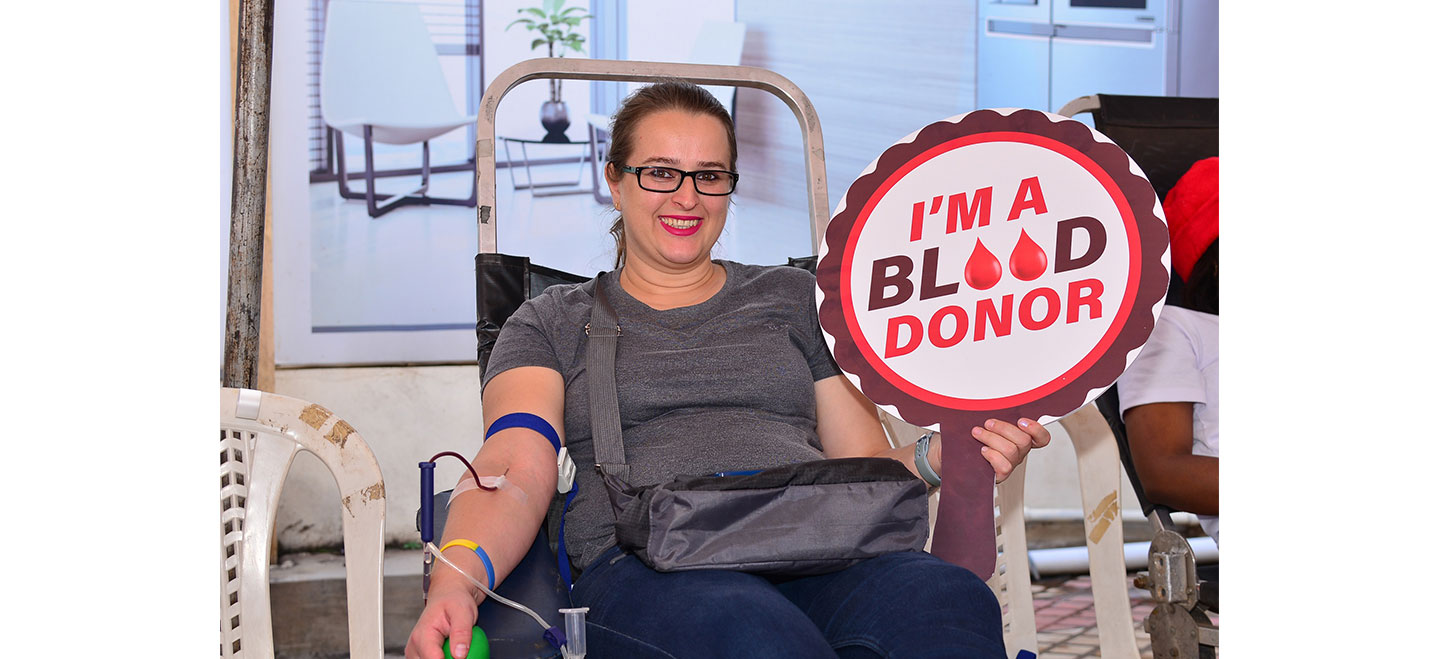 A participant of Life's Good Blood Drive holding a panel that reads, 'I'm a blood donor'