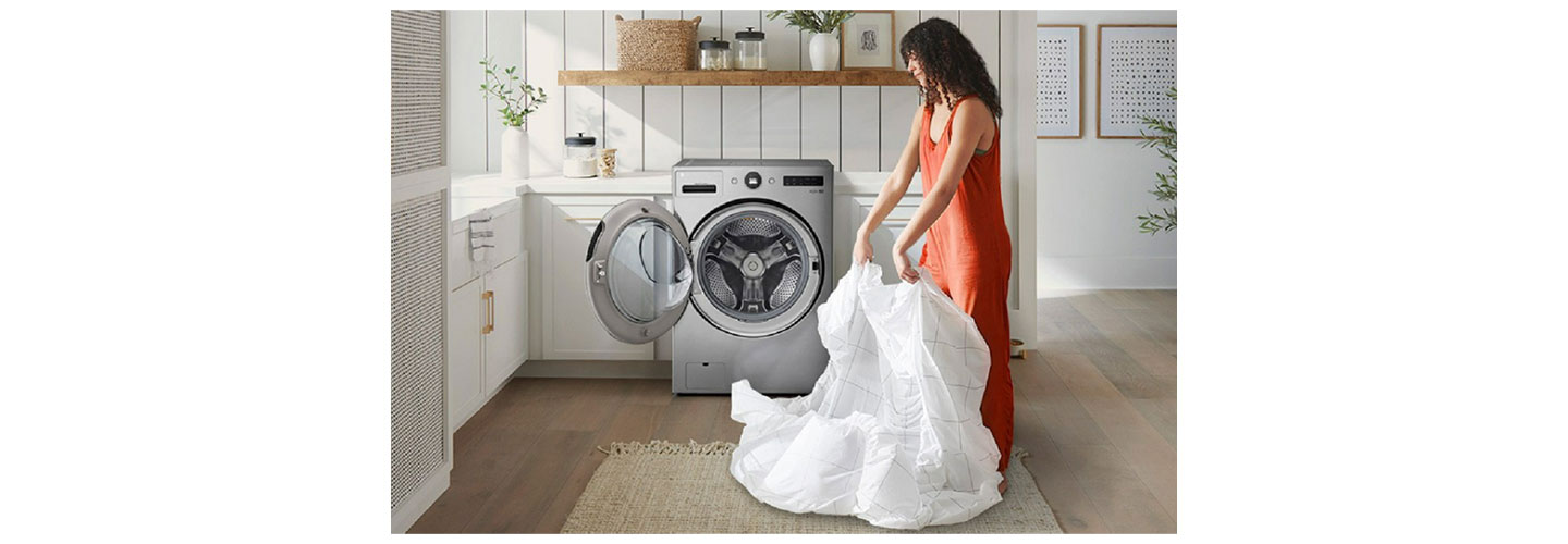 An image of a woman taking the laundry out of the LG WashCombo