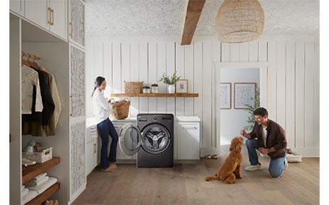An image of a woman using the LG WashCombo and a man with a dog next to her