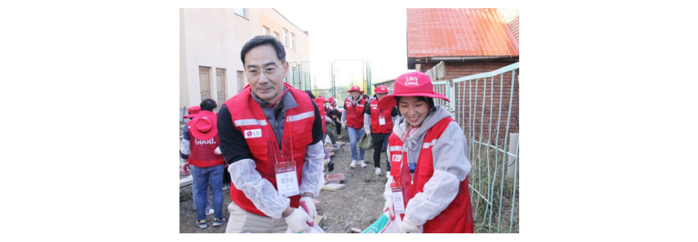 Two Life's Good volunteers carrying a heavy sac together