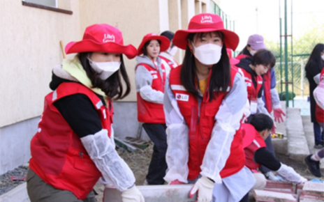Two Life's Good volunteers moving a heavy brick together
