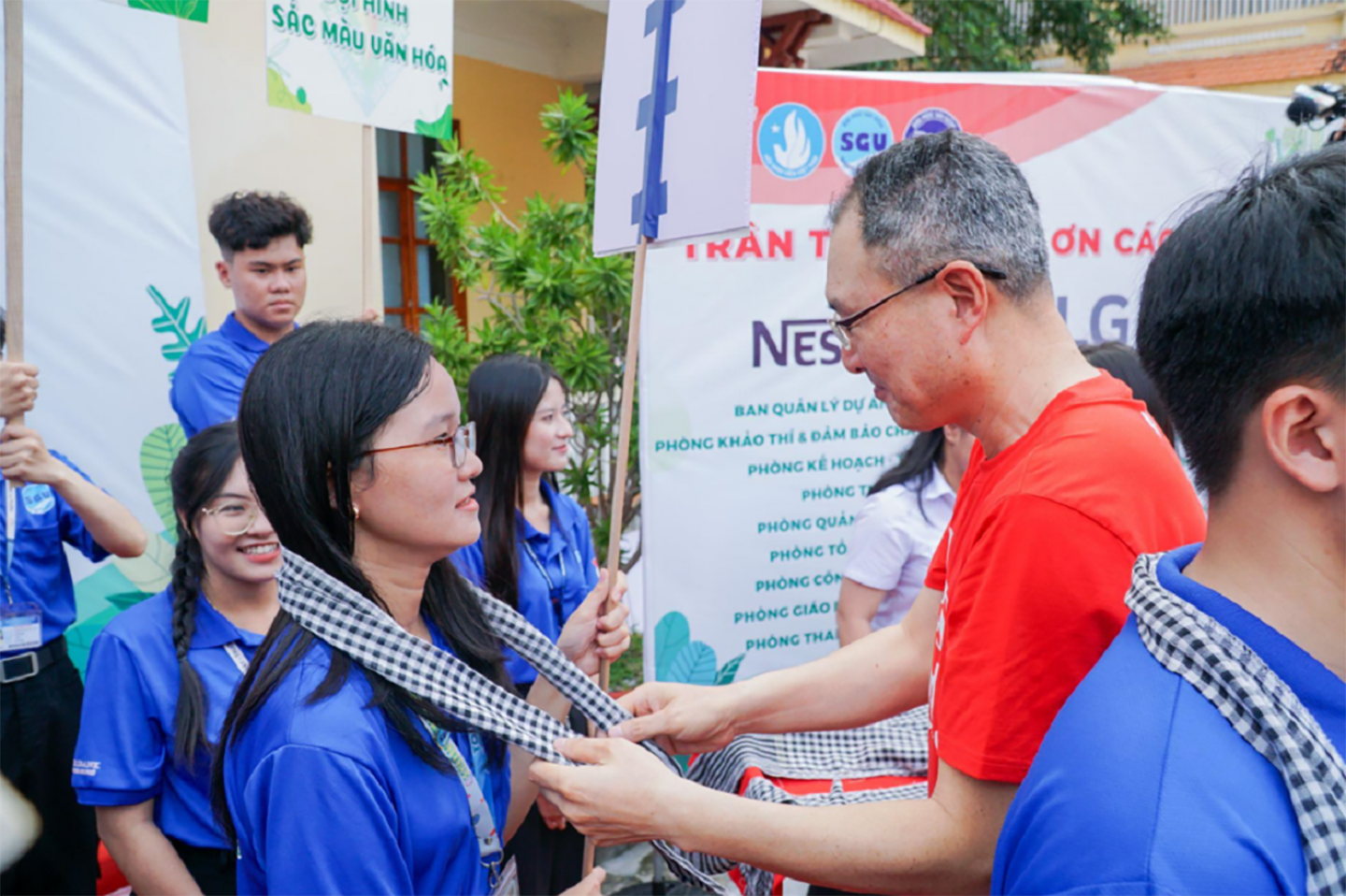 A picture of a man helping a student from the Green Summer 2024 Campaign
