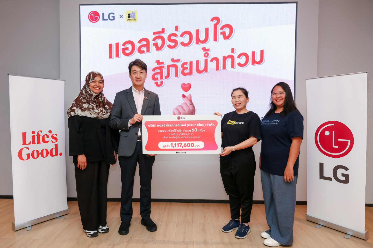 Members of LG Thailand and the Mirror Foundation stand together while holding a sign to announce the donation of 60 essential home appliances.