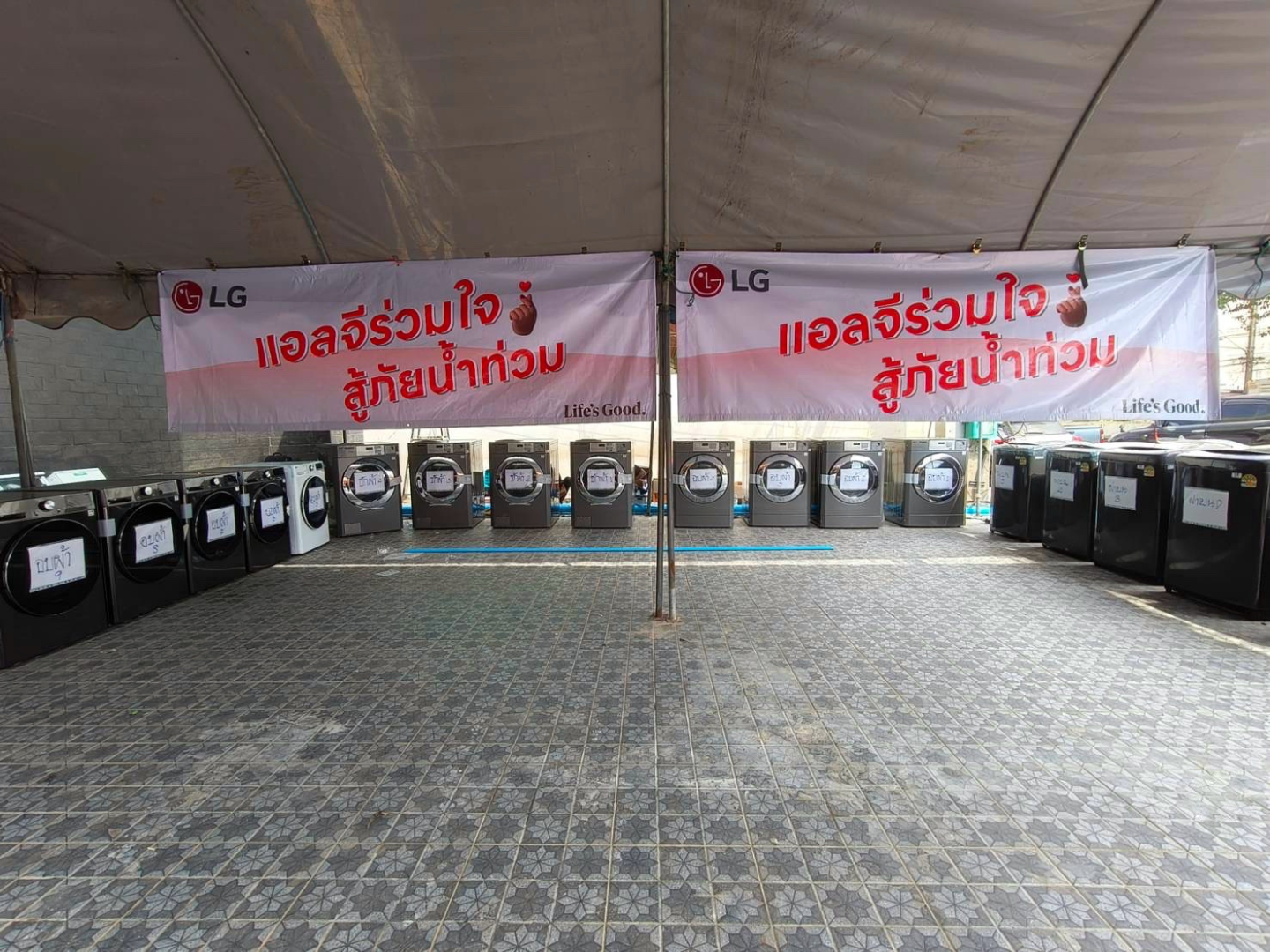 Multiple LG washer and dryer units are displayed in an open space with a "Life's Good" banner above.