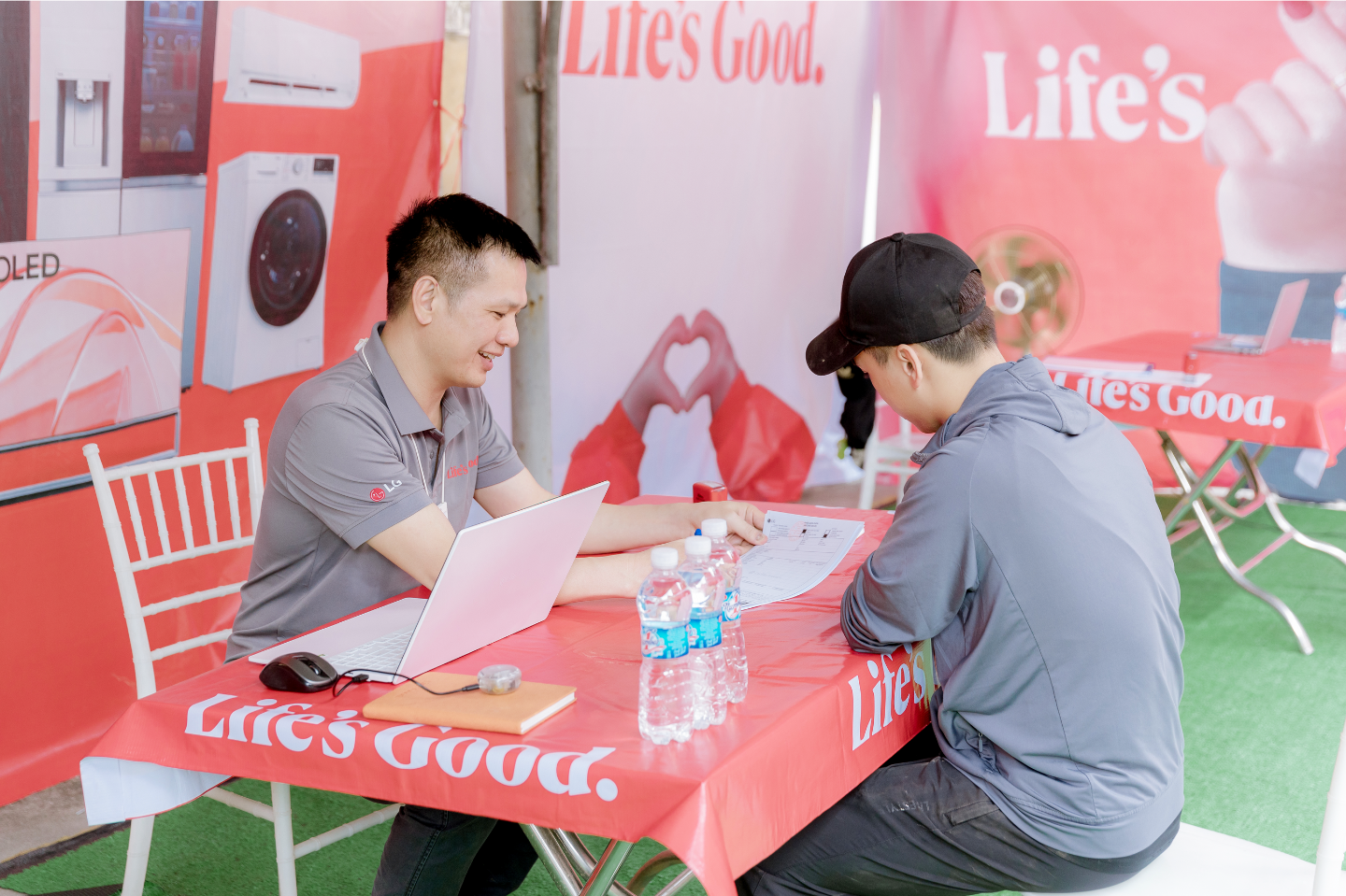 An LG employee provides a consultation in an outdoor setting with "Life's Good" logos visible throughout the area.