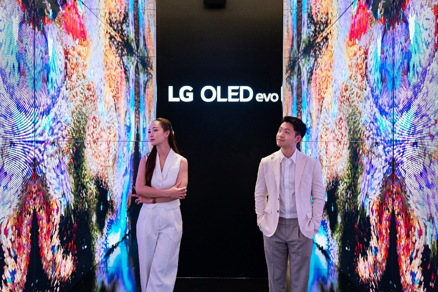 A man and a woman taking a photo in the background of the screen at multi-sensory experience space
