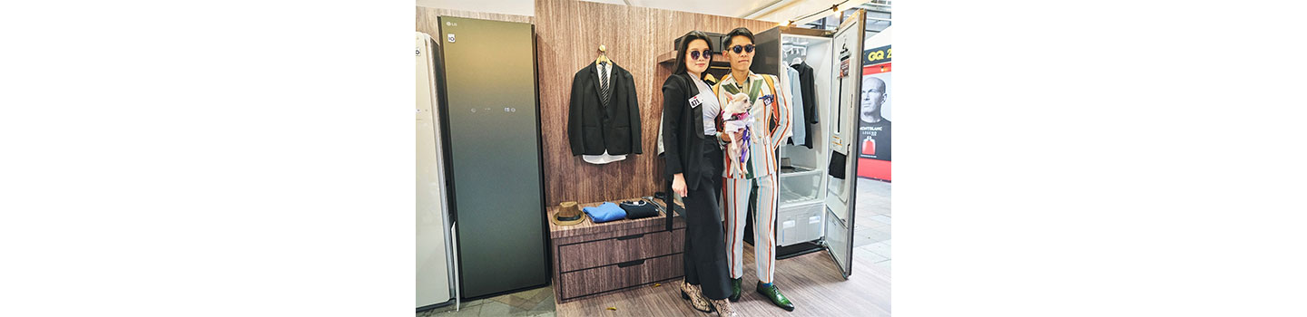 Two visitors posing in front of LG Styler at LG booth during GQ Suit Walk