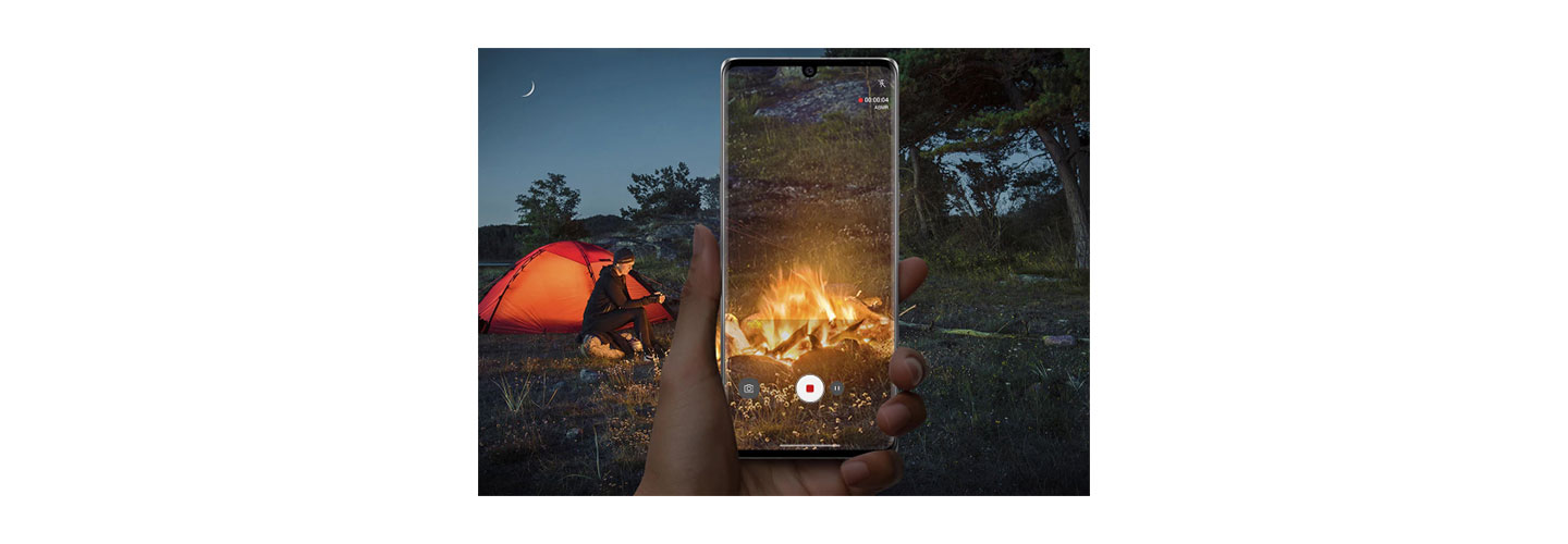 A person using LG VELVET's ASMR recording feature and Voice Bokeh to record a campfire during a trip with friends
