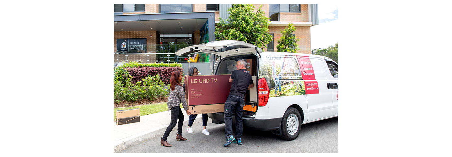 RMHC staff taking donated LG UHD TV out from a van