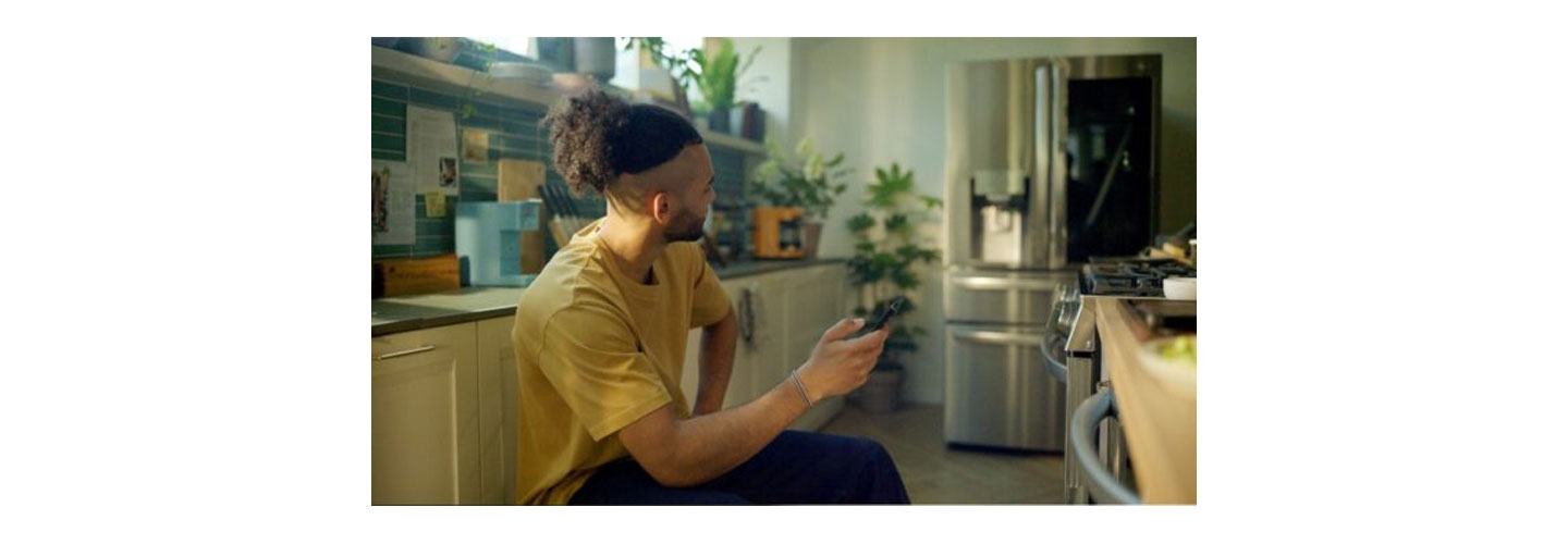 A man using his phone in the kitchen