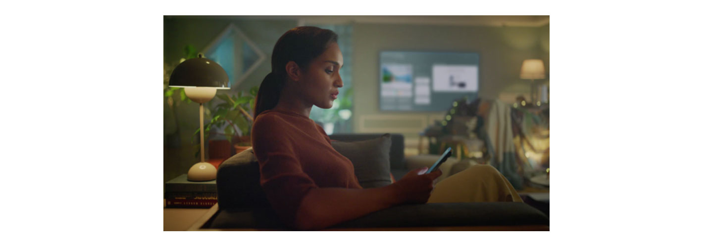 A woman using her phone in the living room