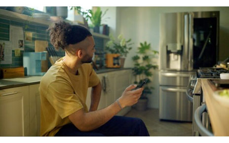 A man using his phone in the kitchen