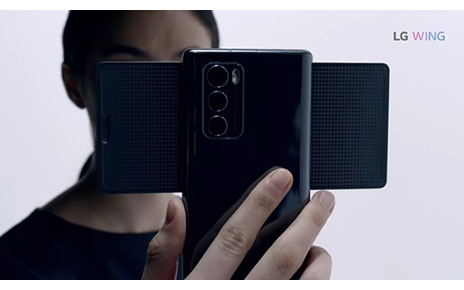 A person holds LG WING in Swivel Mode with the three rear camera lenses clearly seen