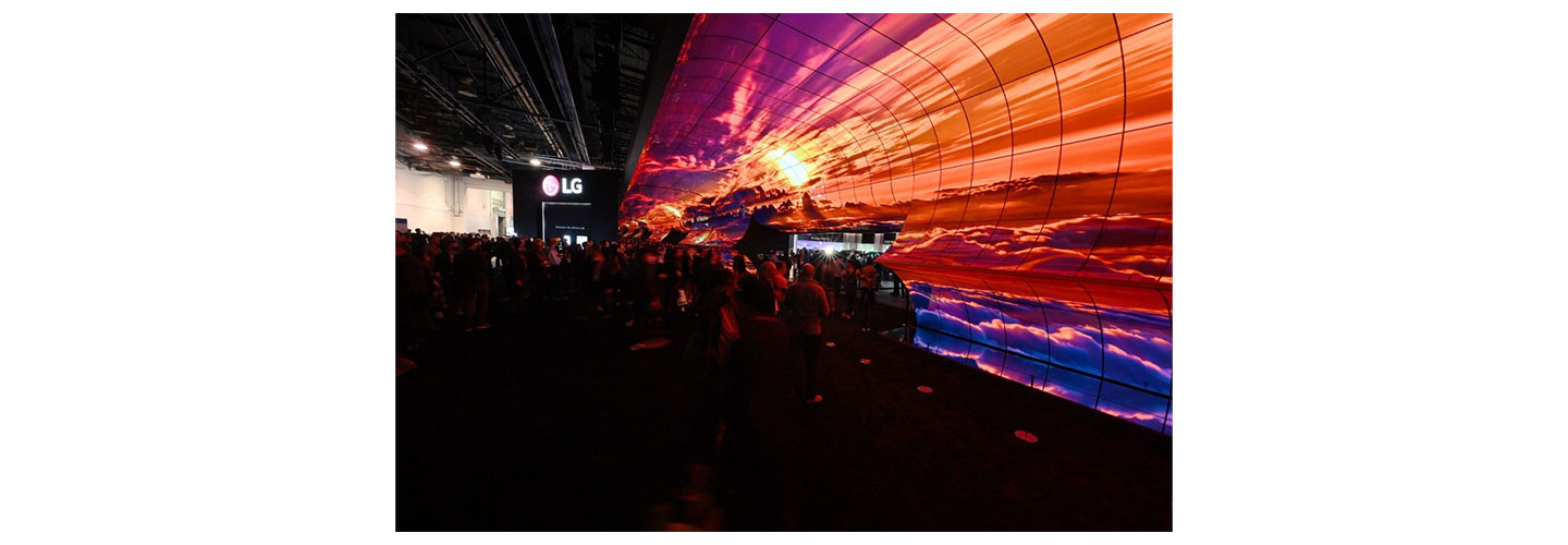Two of LG’s newly unveiled LG Transparent OLED model displayed in a dark room with bright lights, one transparent and the other displaying content
