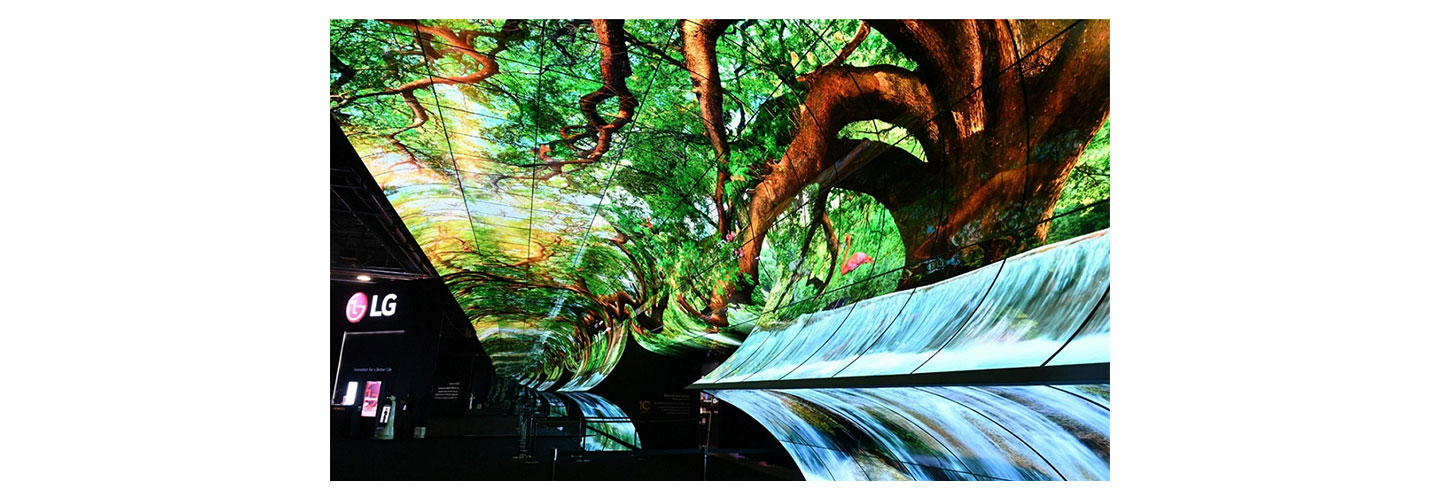 LG OLED Horizon installed at LG booth during CES 2023 displaying big trees and waterfall