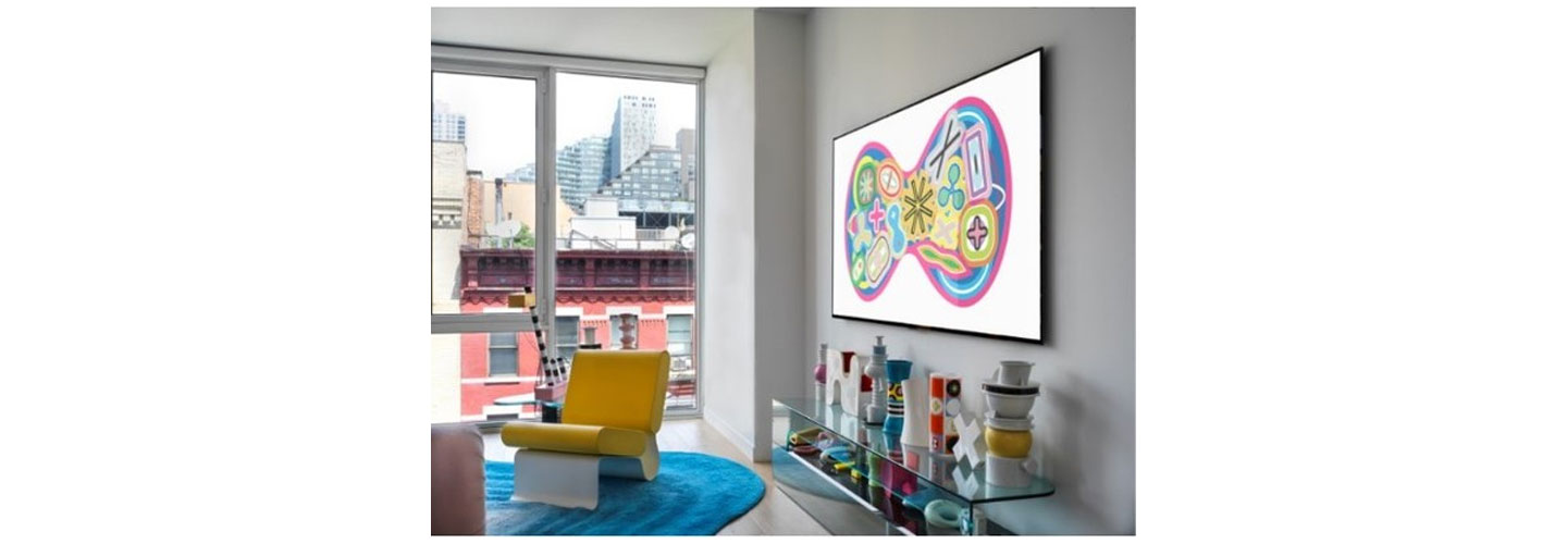 A room with a view is decorated with colorful items and the wall-mounted LG GALLERY DESIGN TV which is displaying Karim Rashid’s KOSMOS