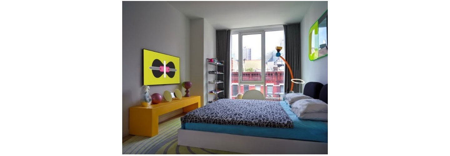A uniquely decorated bedroom with one of LG’s GALLERY DESIGN TVs displaying Karim Rashid’s KARMA on the left-side wall